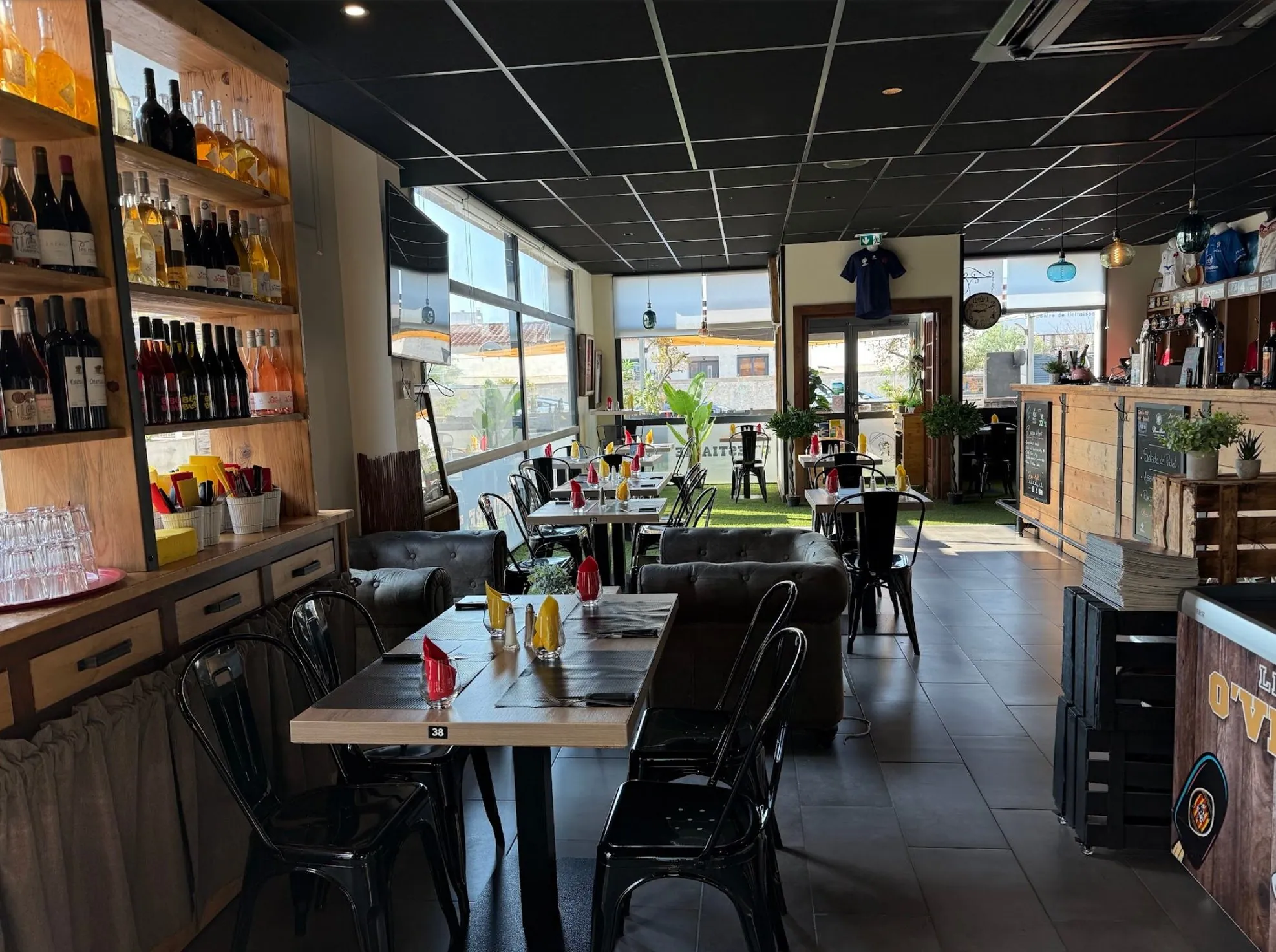 La salle de brasserie d’O’Vestiaire, ses tables, son comptoir et sa pelouse intérieure
