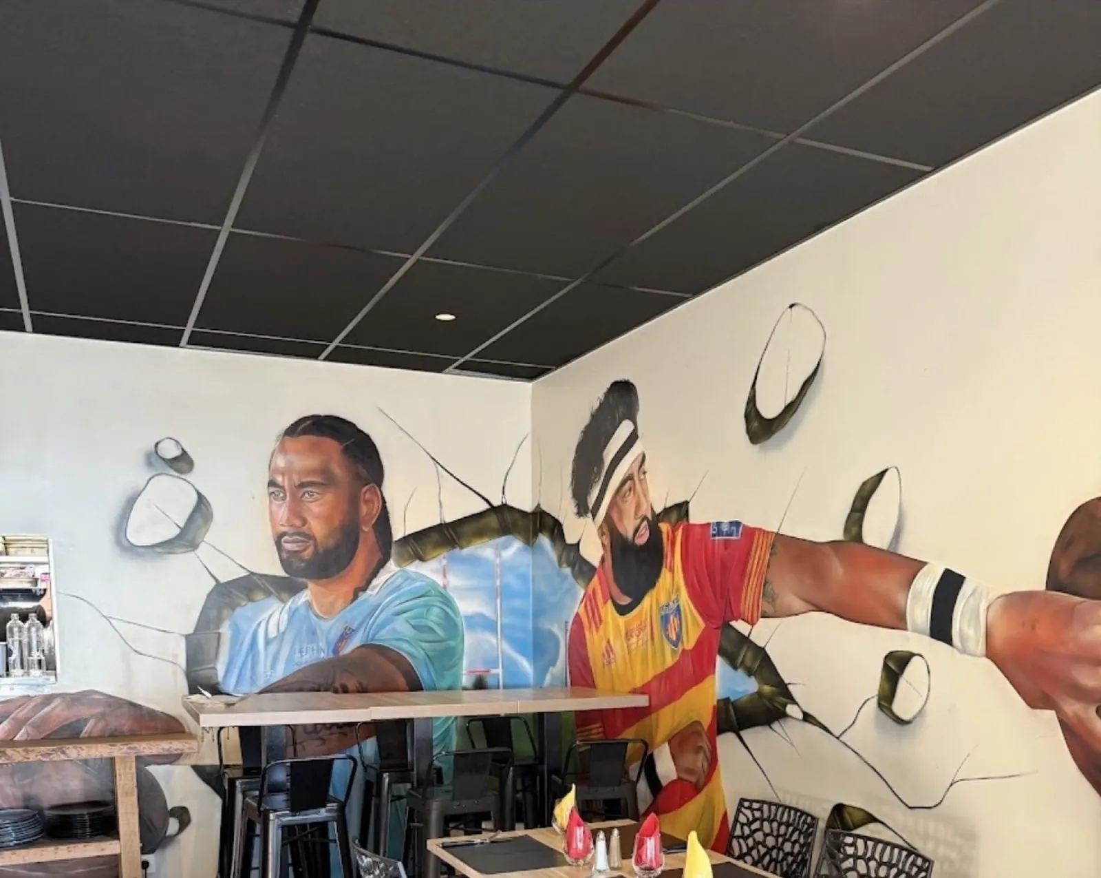 Deux joueurs de rugby peints grandeur nature sur le mur de la salle