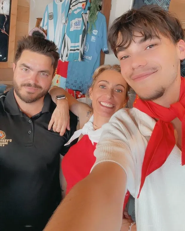 Clients et équipe en selfie, sous les maillots accrochés